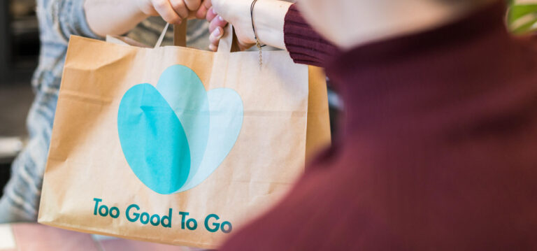 Papiertüte von too good to go wird übergeben