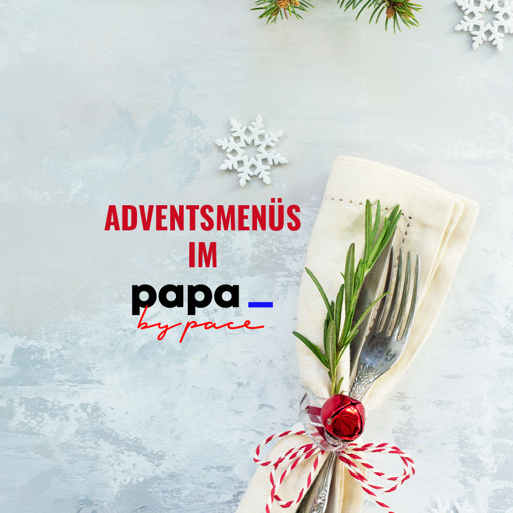 Ein festlich gedeckter Tisch mit Gabel und Messer, eingewickelt in eine Serviette, geschmückt mit Rosmarin, einer roten Glocke und einem Band. Schneeflocken und Tannenzweige setzen die Szene in Szene. Text: Festtag Adventsmenüs im PAPA von pace.