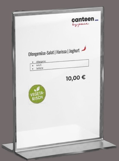 Ein Schild auf der Speisekarte zeigt ein Gericht namens Ofengemüse-Salat | Harissa | Joghurt zum Preis von 10,00 €. Kitchen Insights weist auf Allergene wie Milch und Sellerie hin. Ein grünes "Vegetarisch"-Etikett ist enthalten.