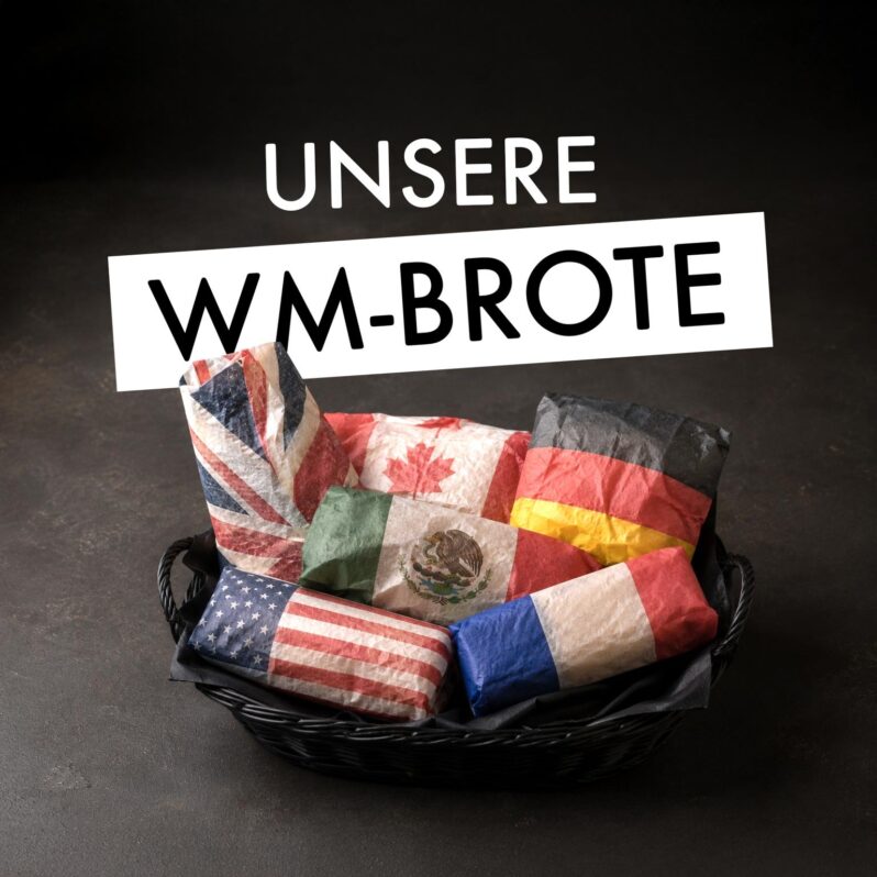Ein Korb mit Brotlaiben, eingewickelt in Papier mit verschiedenen Länderflaggen - Großbritannien, USA, Kanada, Mexiko, Deutschland und Frankreich - lädt Sie zu einer kulinarischen Weltreise ein. Der deutsche Text darüber lautet UNSERE WM-BROTE. Perfekt für jede DELI-Auslage.