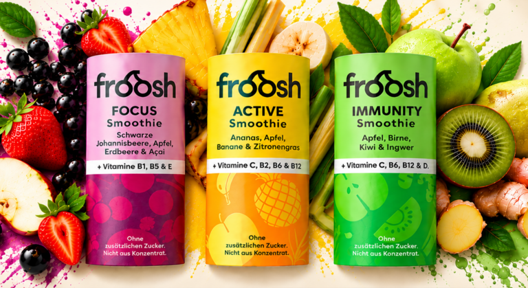 Drei Froosh-Smoothie-Flaschen in Rosa, Gelb und Grün – entwickelt für mehr Konzentration und einen aktiven Lebensstil – umgeben von frischem Obst und bunten Farbtupfern.